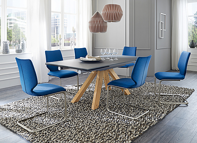 Extravagantes Esszimmer mit gräulichem Tisch und blauen Stühlen