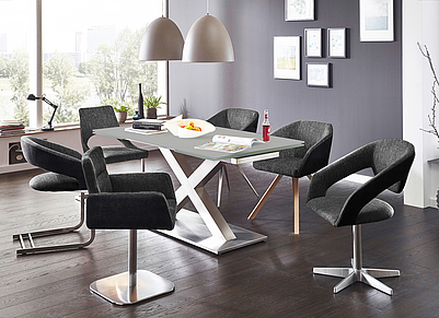 Ästhetisches Esszimmer mit Edelstahlfarbenem Tisch und schwarz-grauen Stühlen