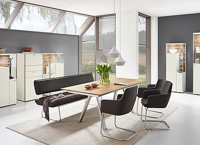 Ausdruckstarkes Esszimmer mit furniertem Eichenholz-Tisch und grau-brauner Sitzgarnitur