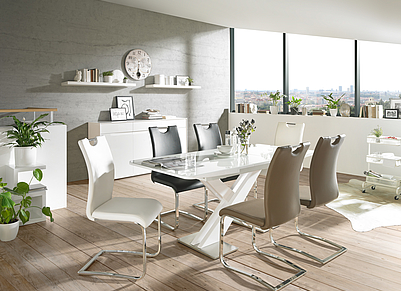 Extravagantes Esszimmer mit weißem Tisch und verschiedenfarbigen Lederstühlen